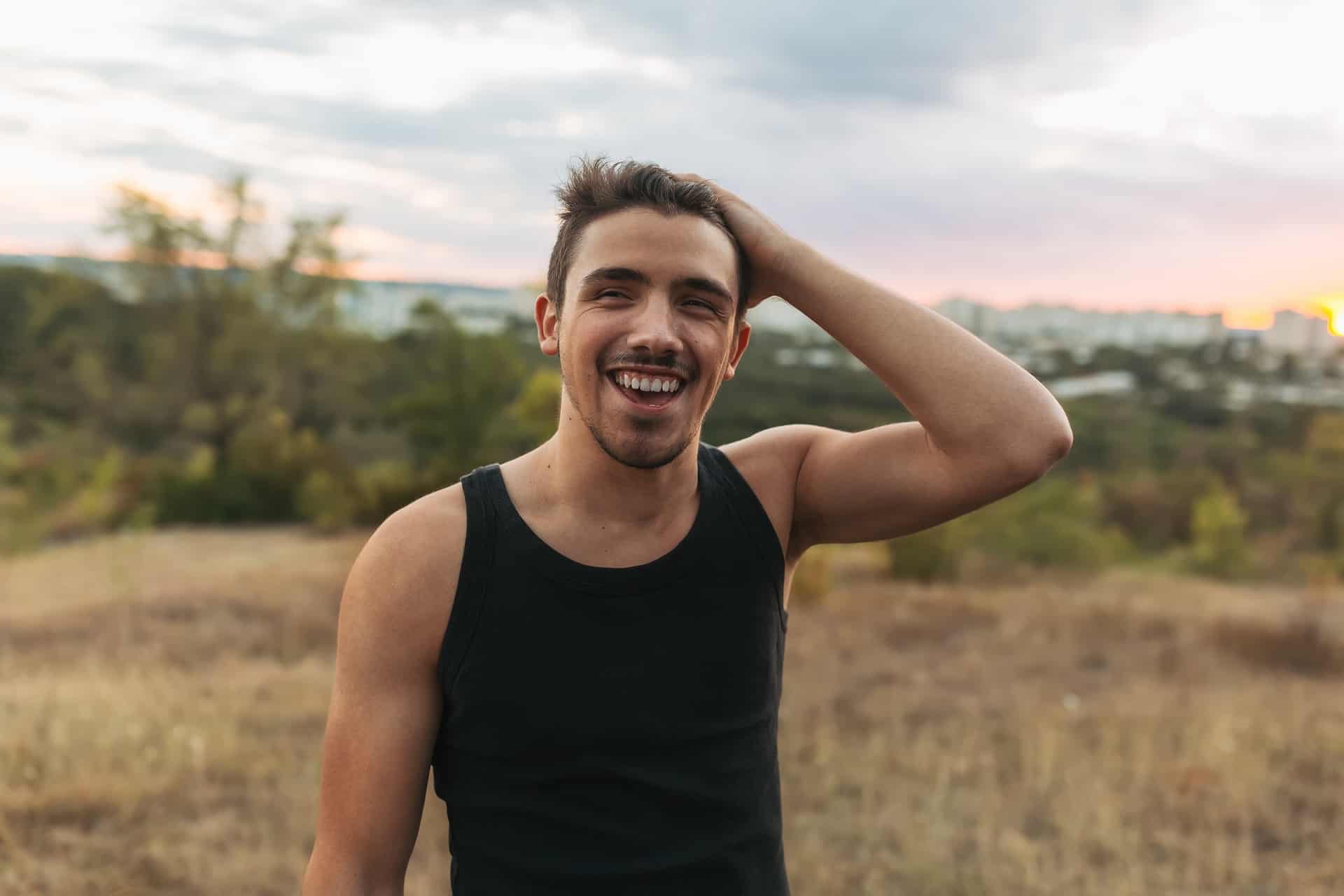 Portrait of a happy smiling man on nature and city background. Good-looking young man love life.